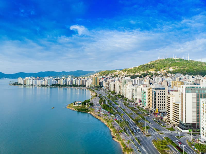 Vista aérea de Florianópolis com urbanização litorânea e infraestrutura para aviação executiva.